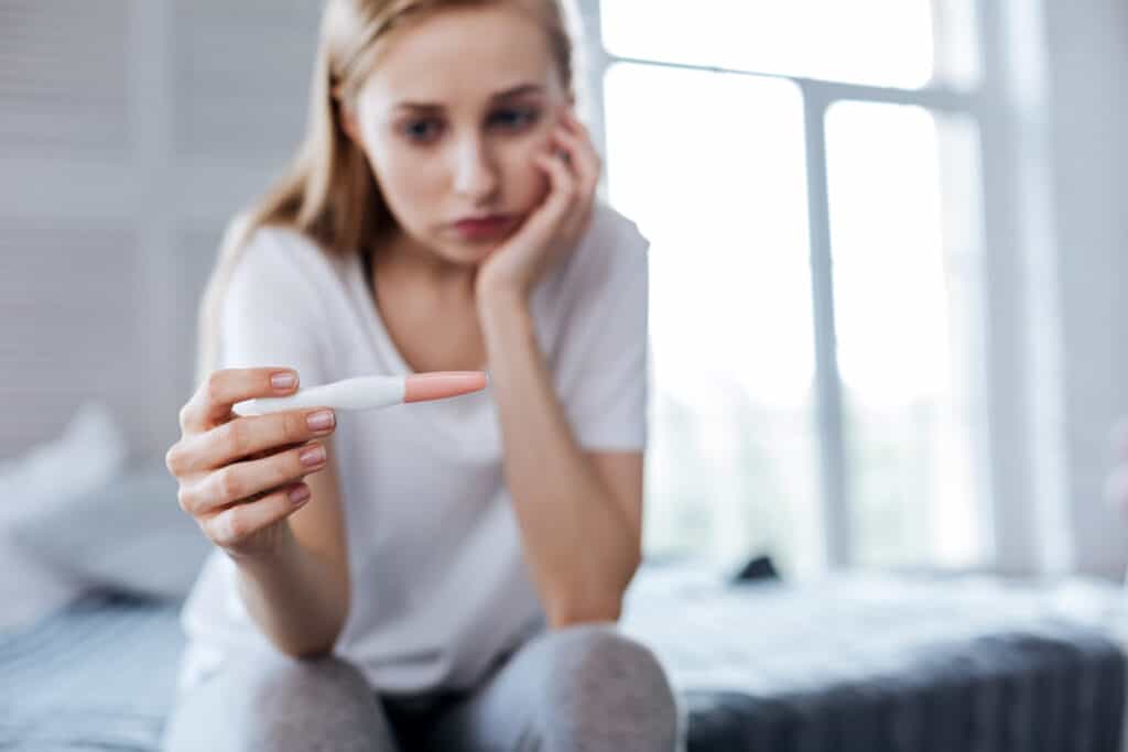 Sad woman holding her pregnancy test
